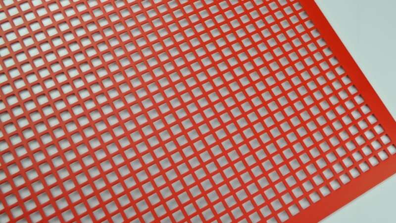 La chapa perforada roja con orificios cuadrados después del recubrimiento en polvo